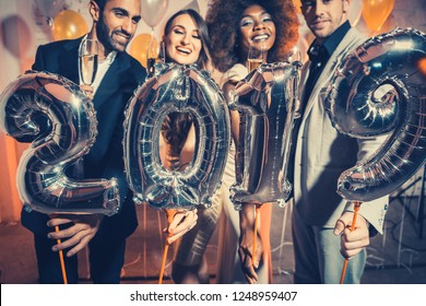 Party people women and men celebrating new years eve 2019 with sparklers and Champagne 