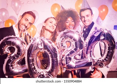 Party people women and men celebrating new years eve 2020 with sparklers and Champagne