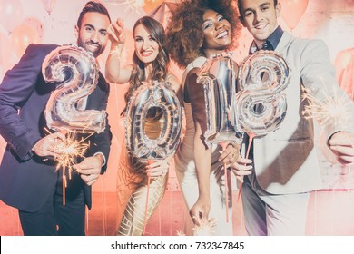 Party people women and men celebrating new years eve 2018 with sparklers and Champagne 