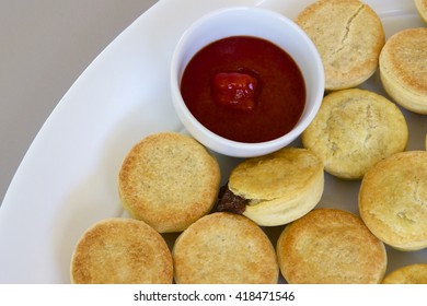 Party Pies On A White Plate With Tomato Sauce.