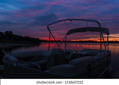 Party Pontoon Boat Against Lake Sunset Sky With Colorful Purple And Blue Clouds