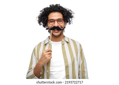 party props, photo booth and people concept - smiling young man with mustache accessory over white background - Powered by Shutterstock