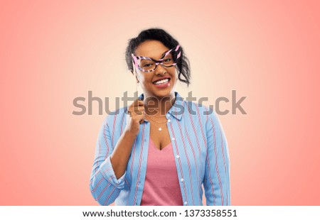 party props, photo booth and people concept - happy african american young woman with big glasses over living coral background