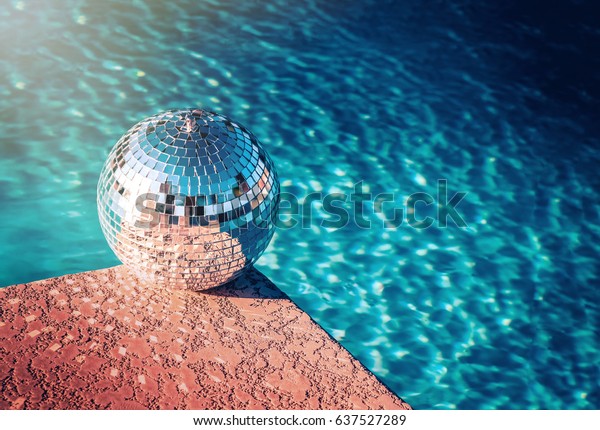 Party rave\
event disco ball beside swimming pool\
