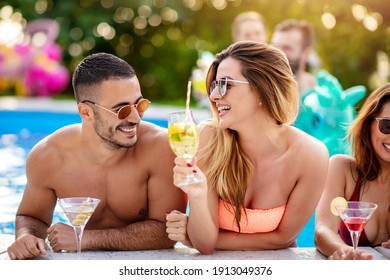 Party at smimming pool. Group of young friends drinking cocktails in the pool. - Powered by Shutterstock