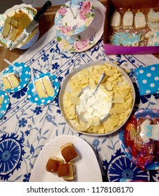 A Party Table Spread At A Baby Shower With Chips, Finger Sandwiches, Cookies, Napkins And Cake