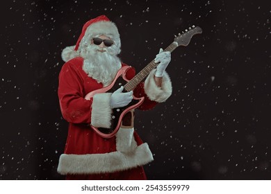 Party time at Christmas and New Year. Modern Santa Claus in black sunglasses plays an electric guitar. Black background with snowfall. Copy space. - Powered by Shutterstock