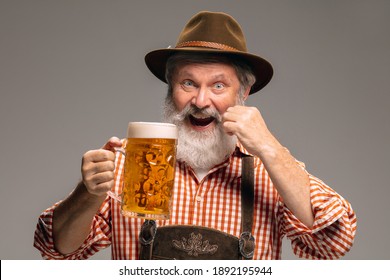 Party time. Happy senior man dressed in traditional Austrian or Bavarian costume with mug of beer on grey studio background. Copyspace. The celebration, oktoberfest, festival, traditions concept. - Shutterstock ID 1892195944