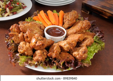 A Party Tray With Chicken Wings And Carrot Sticks