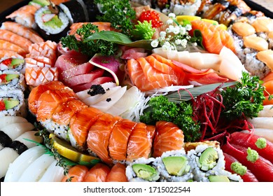Party tray with sashimi, sushi and maki rolls, shallow focus