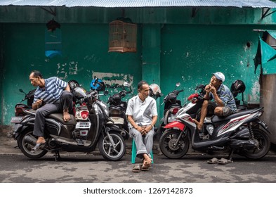 Pasar Baru/ Central Jakarta/ Indonesia - 04/18/18. 3 Senior People Sitting Near The Motor Bike Parking Waiting And Guarding The Parking Lot