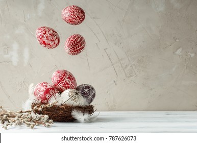 Paschal still life with flying Pysanky and pussy willow branches. Easter eggs decorated with wax resist technique, traditional for Eastern European cultures