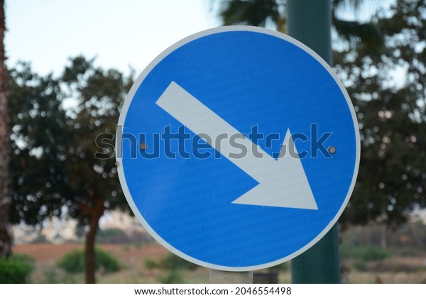 Pass designated place on right. Blue road sign\
Pass on This Side with white arrow pointing to the right. Mandatory\
signs. Road signs in\
Israel
