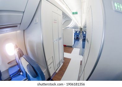 Passage on a passenger plane next to the toilet in economy class - Shutterstock ID 1906181356