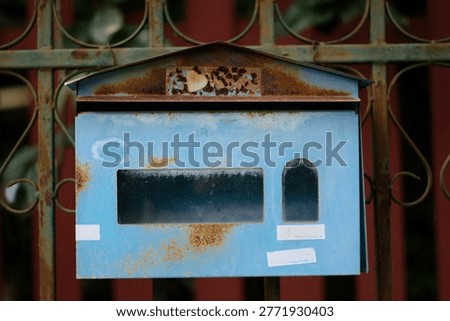 The passage of time: A rusty blue postbox waiting for letters.