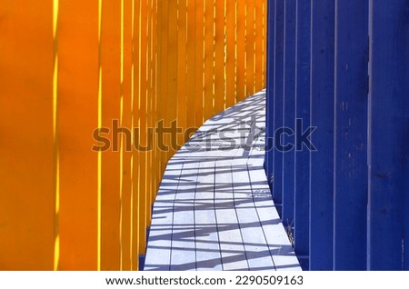 Passageway with blue and yellow wooden slats