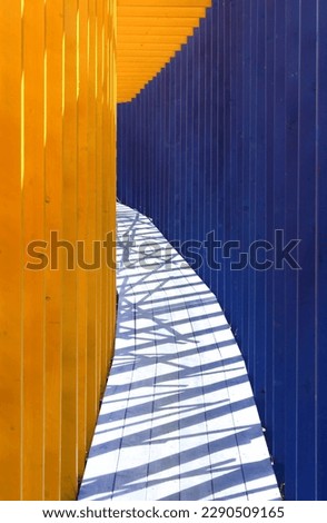 Passageway with blue and yellow wooden slats
