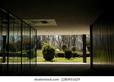 Passageway with a garden in the background reflected in a large glass structure