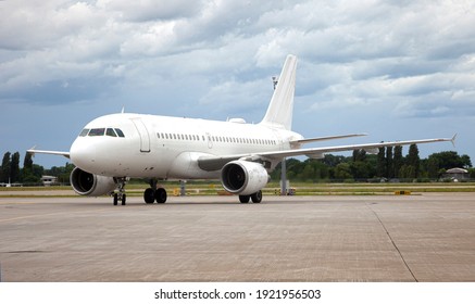 Passanger white plane lands. Airplane on the platform of Airport. Runway. Landing aircraft closeup. Mockup plane with place for text. Cloudy sky. Copy space. Cloudy sky. - Powered by Shutterstock