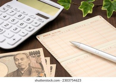 Passbook, calculator and Japanese money. The passbook is written in Japanese as 