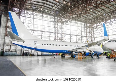 Passenger Aircraft On Maintenance Of Engine And Fuselage Repair In Airport Hangar. View Airplane Completely From Behind To Tail