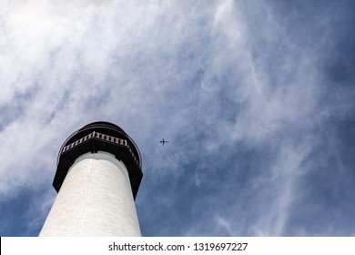 passenger aircraft plane flying over a white lighthouse in Miami Florida against a blue sky - Shutterstock ID 1319697227