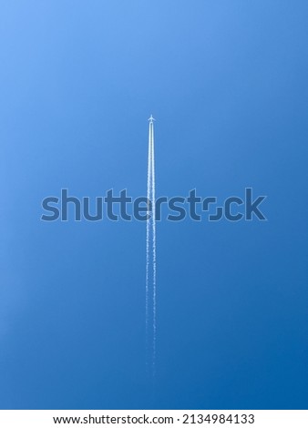 Passenger airplane in flight in clear blue sky, directly below