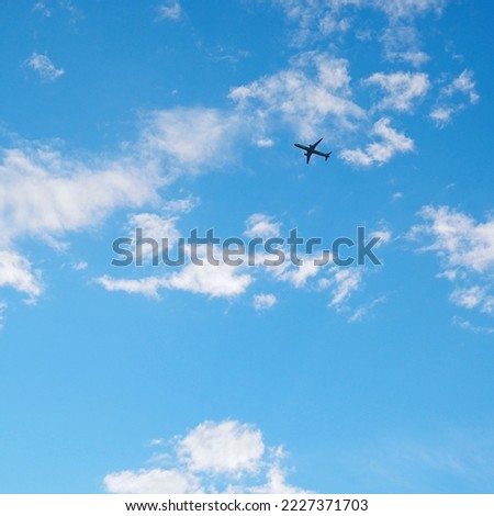 The passenger airplane is flying far away in the blue sky and white clouds. Aircraft in the air. International passenger air transportation. Square illustration