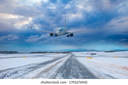 Passenger Airplane Landing To Airport With Snowy Runway