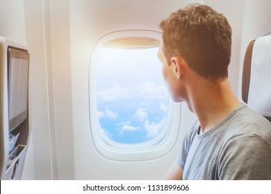 Passenger Of Airplane Looking At Window, International Travel, Happy Man Tourist Enjoy Flight In Comfortable Air Plane