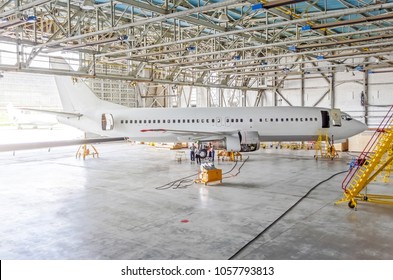 Passenger Airplane On Maintenance Of Engine, Check Repair In Airport Hangar. Aircraft Side View, Open Hangar Doors