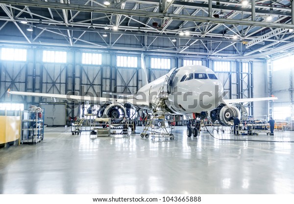 Passenger airplane on maintenance of\
engine and fuselage check repair in airport\
hangar