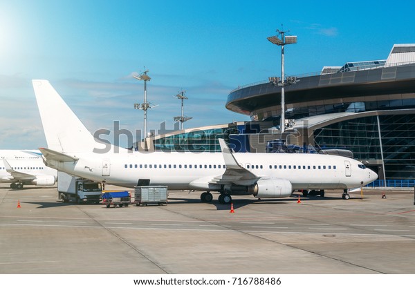 Passenger airplane is parked in the air ticket\
in the air ticket, waiting for the\
flight