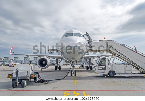 Passenger airplane in the parking at the airport\
with a nose forward and a\
gangway