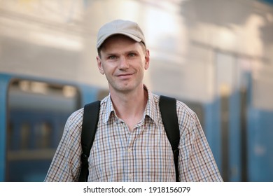 Passenger with backpack against a train before departing