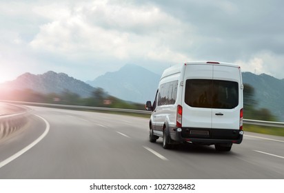 passenger bus van accelerating on a background of mountains - Shutterstock ID 1027328482
