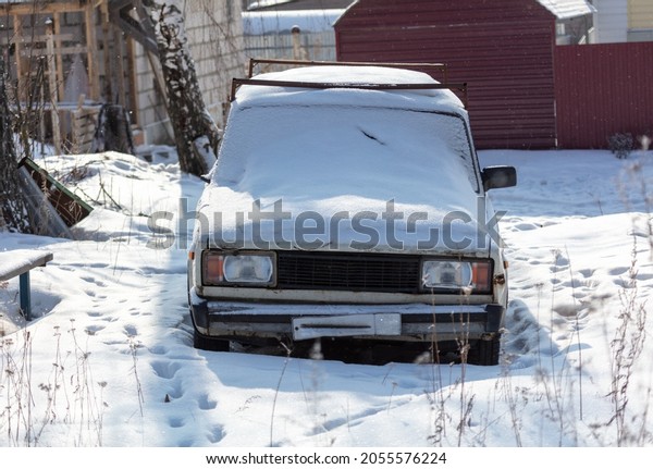 A passenger\
car covered with snow in\
winter.