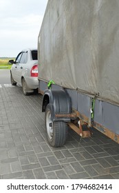 A Passenger Car With A Large Tilt Trailer.