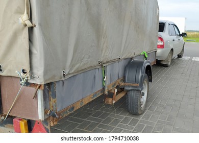 A Passenger Car With A Large Tilt Trailer.