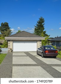 Passenger Car Parked On Bar Colored Concrete Driveway Nearby Double Garage. 