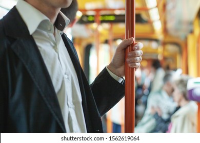 Passenger Commuter In Public Transport, Commuting People In Bus Or Tram, Close Up Of Hand Holding Handrail Bar