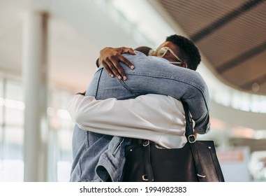 Passenger Couple Giving Warm Embrace At Airport. Man Giving Warm Welcome Hug To Woman At Airport Terminal.