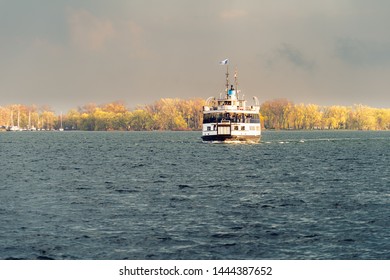 A Passenger Ferry Sails Across Toronto Harbour At Sunset