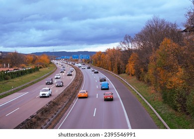 Passenger and freight vehicles travel along A5 autobahn in Germany, with Taunus mountains in background, Transport Network, Safety Traffic on Road, Modern City Living