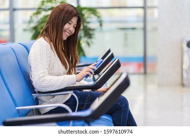 passenger holding and scanning mobile phone with qr code scanner machine of message chair in airport, Technology with travel and tourist, check-in self service,transportation concept,