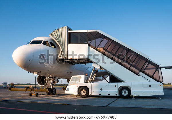Passenger jet plane with boarding steps at the
airport apron