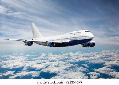 Пассажирский реактивный самолет в небе. Самолет летит высоко над облаками.