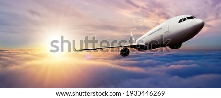 Passenger jetplane flying above clouds in sunset. Beautiful sunset scenery, transportation and fast travel concept.