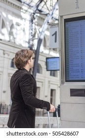 Passenger looking at timetable board at train station