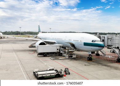 A passenger plane being serviced by ground services before next takeoff.